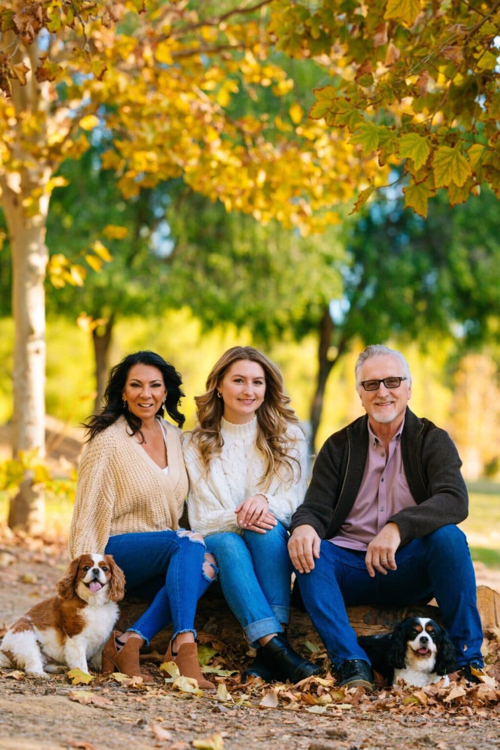 Family outdoor portrait with dogs, capturing joyful moments in autumn.