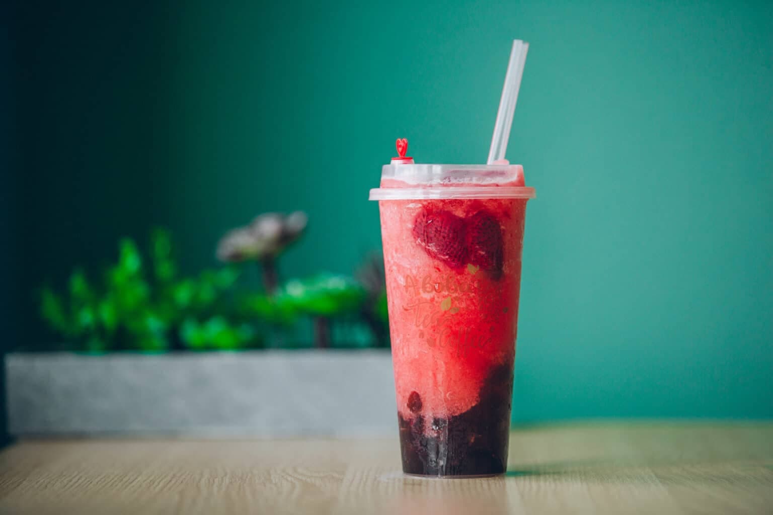 Strawberry smoothie in clear cup with berries, vibrant color, culinary photography