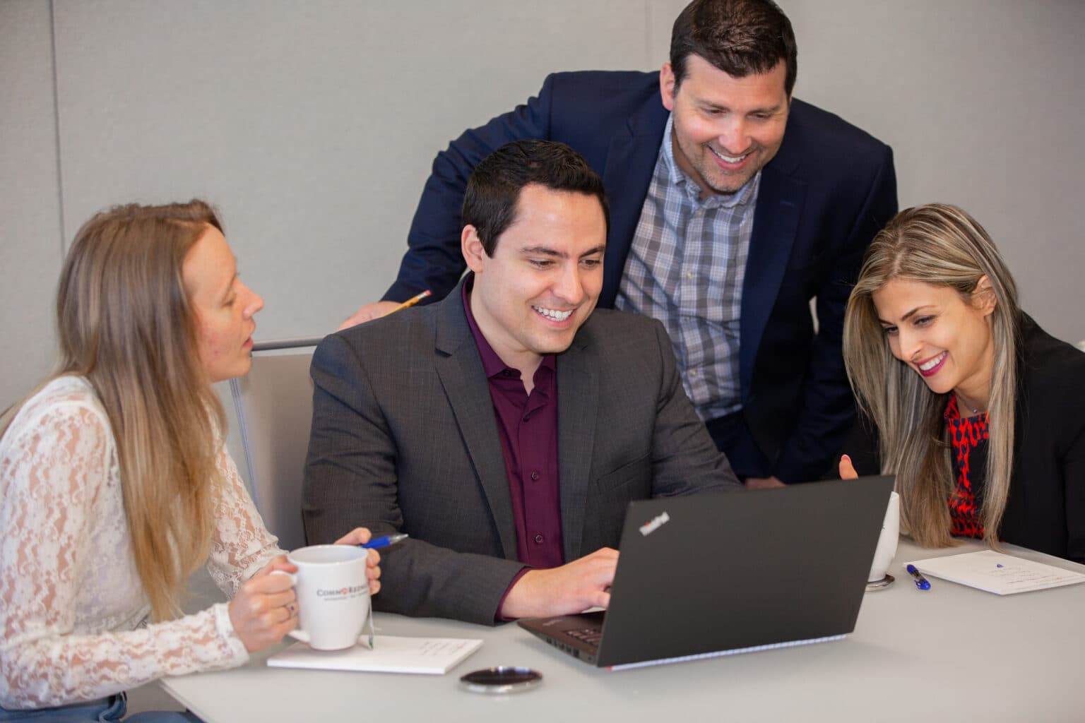 Team discussing business on laptop during corporate meeting.