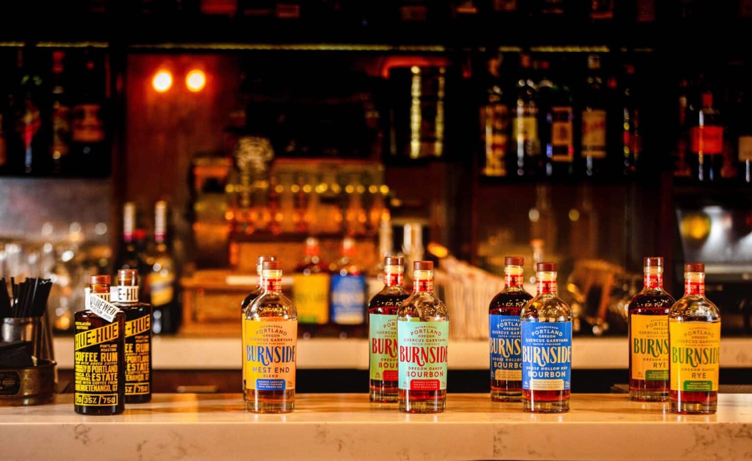 Bottles of Burnside bourbon lined up on bar, culinary photography.
